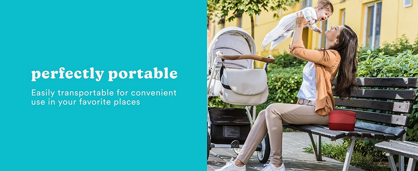 woman sitting on bench next to red bag holding baby